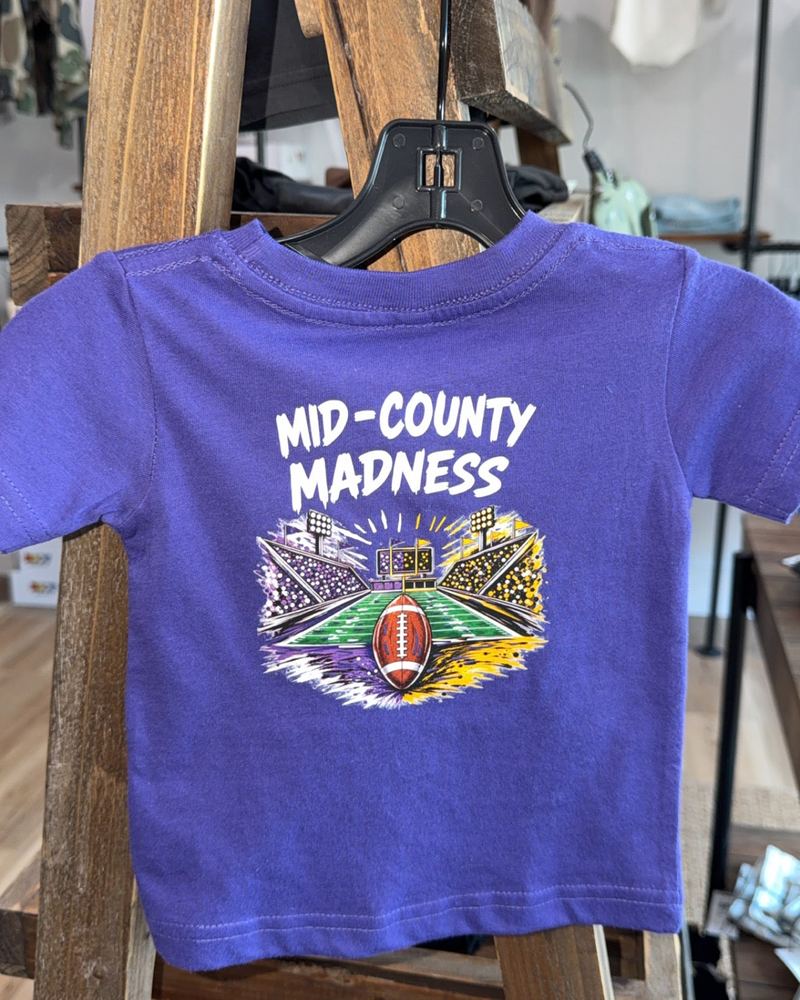 Purple Mid-County Madness kids' tee on a hanger inside KH Baby in Port Neches