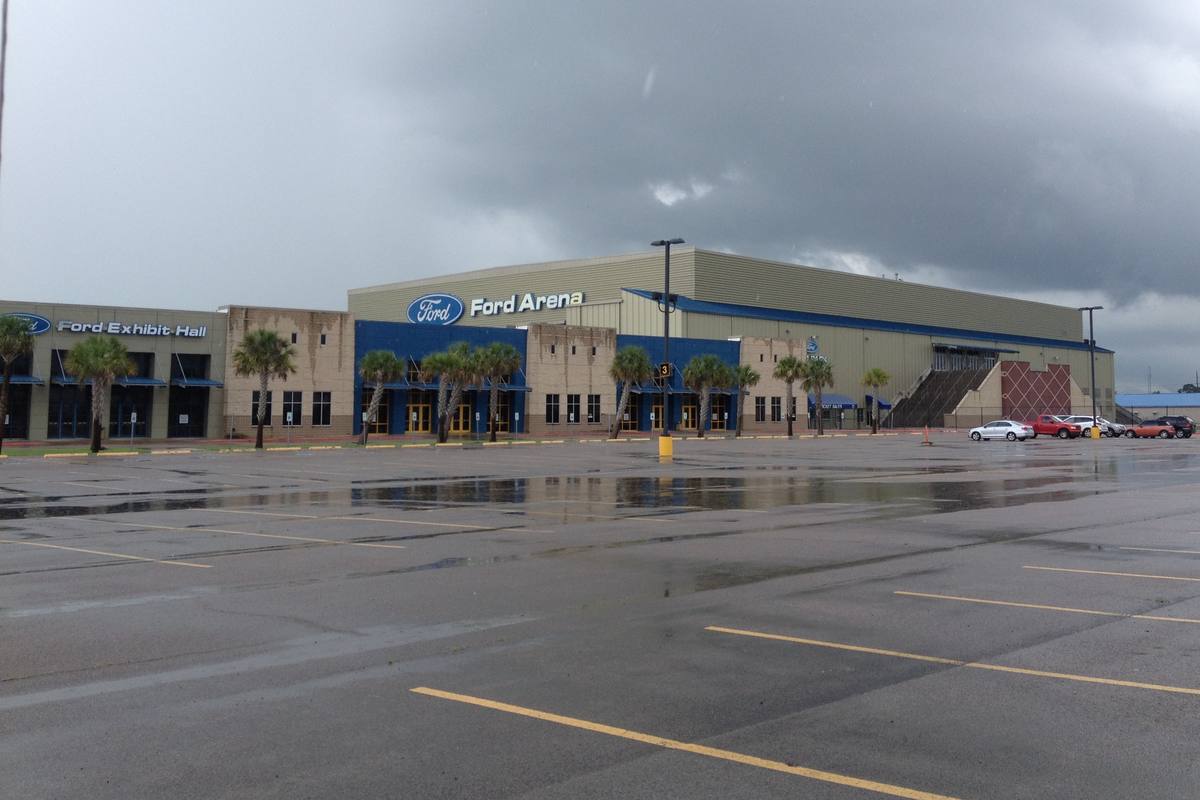The arena and exhibit hall at Doggett Ford Park in Beaumont under a stormy sky, photographed in 2014 under the older Ford Arena signage